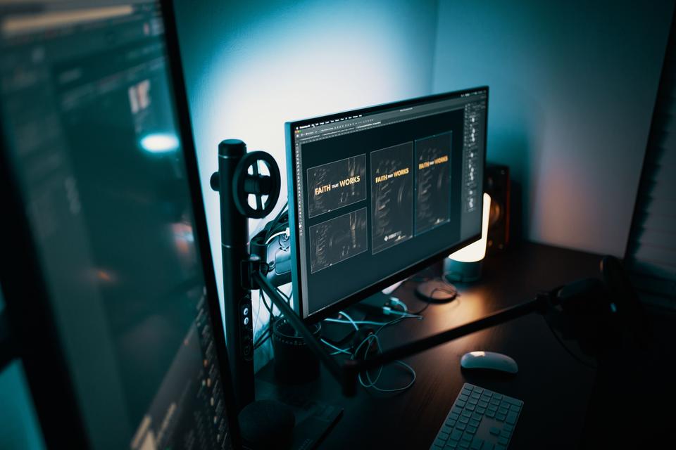 Escritorio con un monitor que muestra diseños editables abiertos en un programa de edición